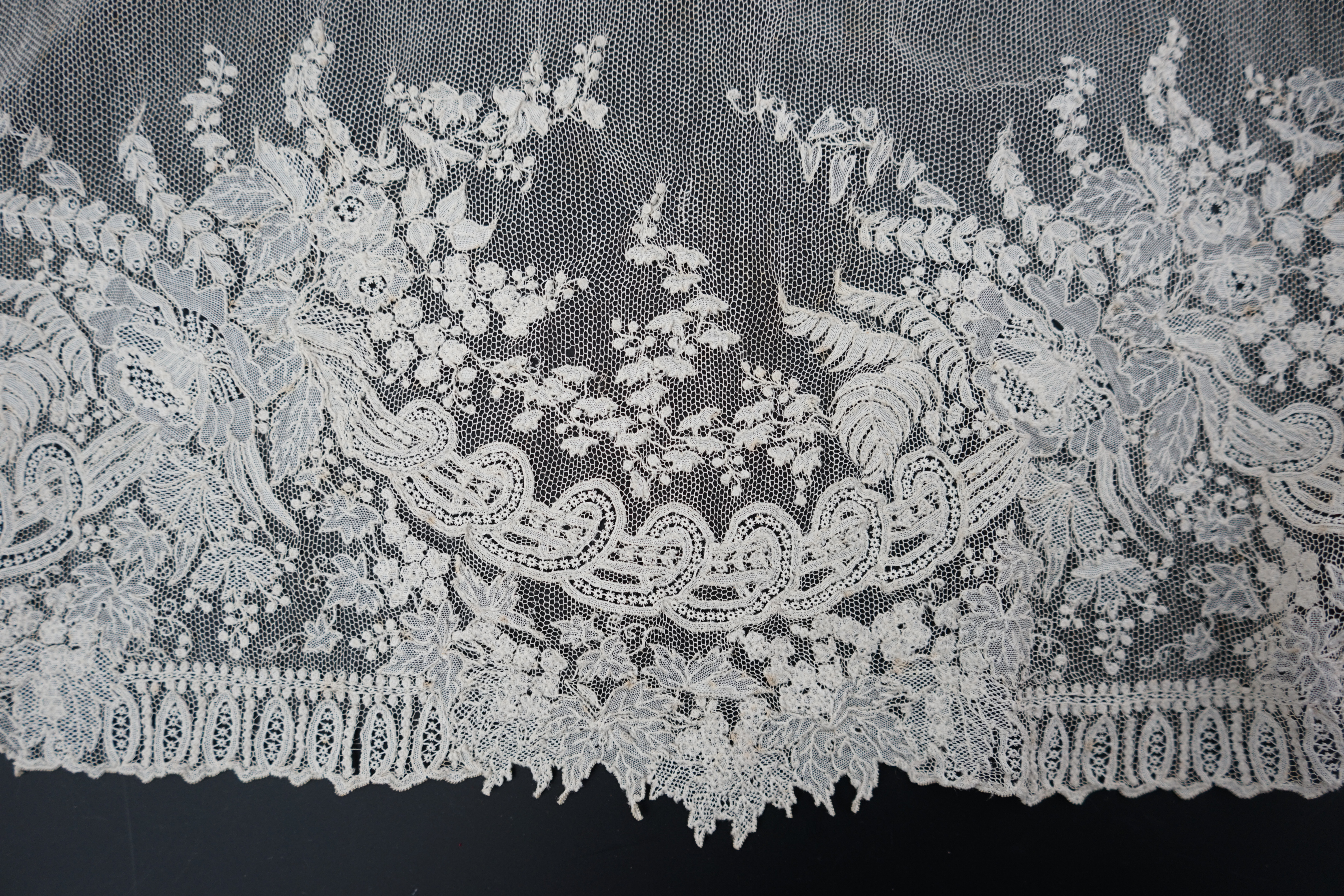 A 19th century Brussels Point de gaze needle lace stole 228cm long x 37cm wide, made from two lengths of the same patterned lace, invisibly joined along the centre of the stole, the raw end edges carefully finished with